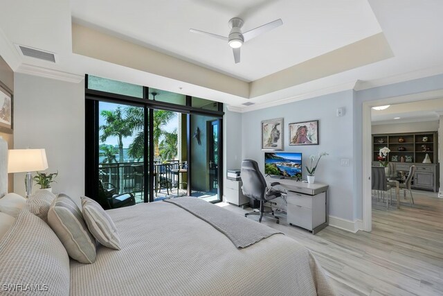 bedroom with access to exterior, an office area, light wood-style flooring, a raised ceiling, and baseboards