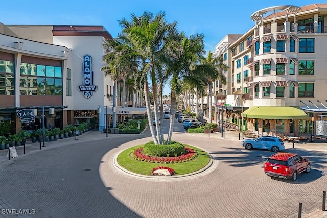 view of decorative road with curbs, street lights, and sidewalks