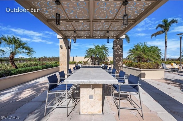 view of patio featuring fence and outdoor dry bar