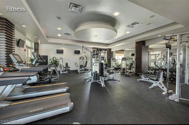 exercise room featuring visible vents and a tray ceiling