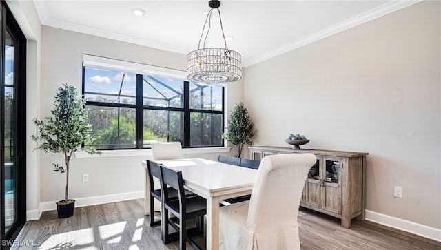 dining area featuring dark hardwood / wood-style floors, ornamental molding, and an inviting chandelier