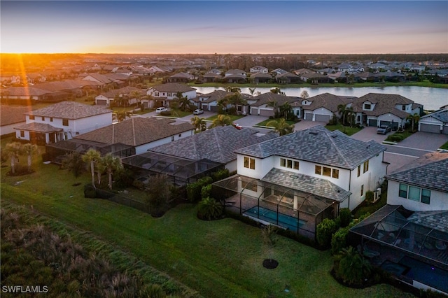 aerial view at dusk featuring a water view