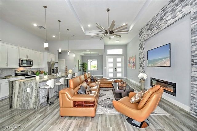 living room featuring light hardwood / wood-style flooring and a high ceiling