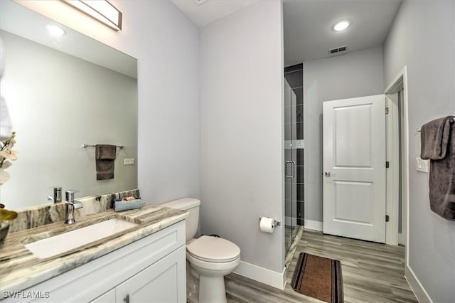 bathroom featuring vanity, an enclosed shower, hardwood / wood-style floors, and toilet