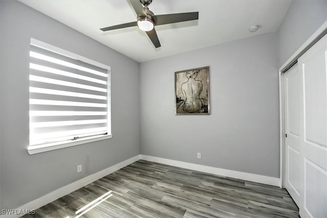 unfurnished bedroom featuring hardwood / wood-style flooring, a closet, and ceiling fan