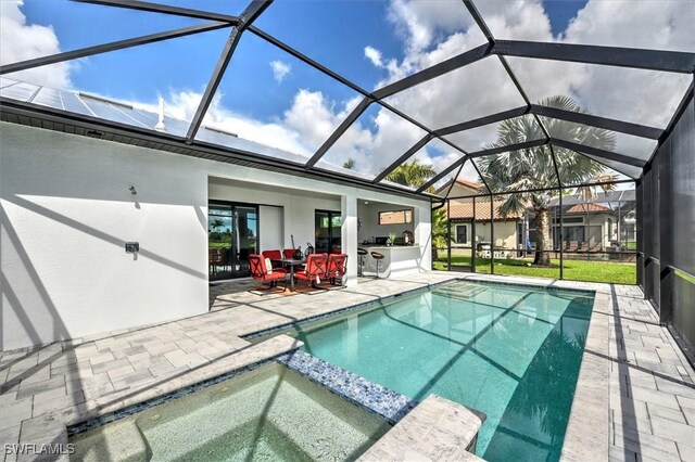 view of swimming pool with a lanai, a patio, and an in ground hot tub