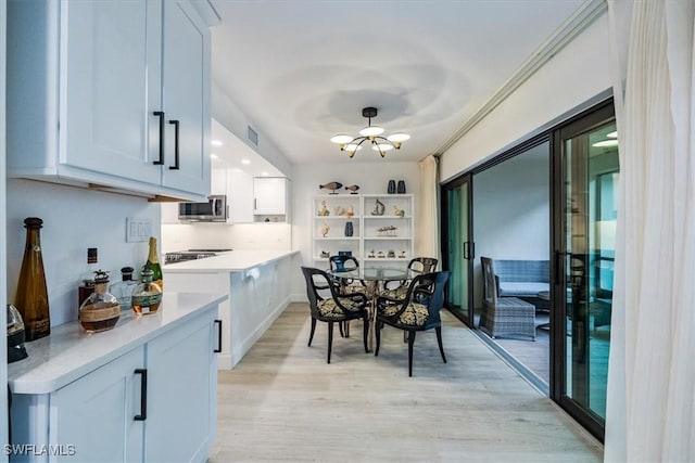 interior space featuring light wood-style floors, light countertops, stainless steel microwave, and white cabinetry