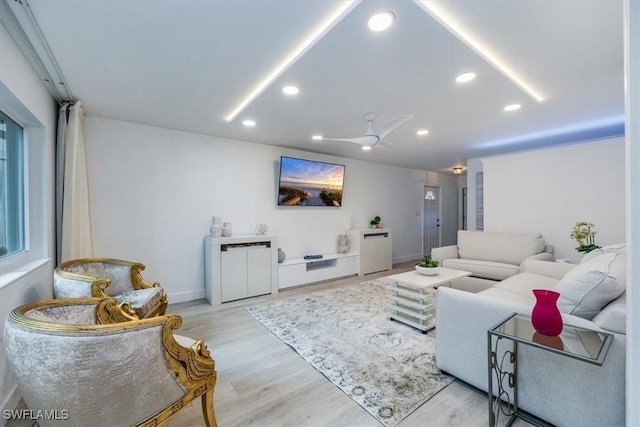 living area with a ceiling fan, recessed lighting, light wood-style flooring, and baseboards