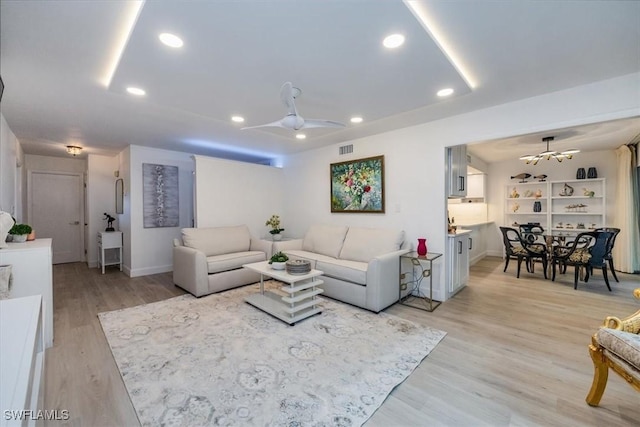 living room with baseboards, visible vents, a ceiling fan, light wood-type flooring, and recessed lighting