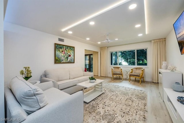 living area with light wood-style flooring, visible vents, and recessed lighting