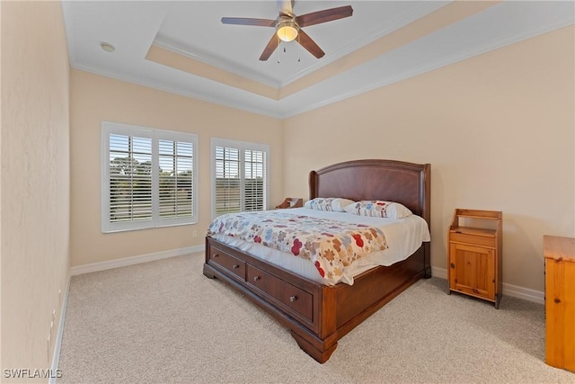 bedroom with ceiling fan, crown molding, light carpet, and a tray ceiling