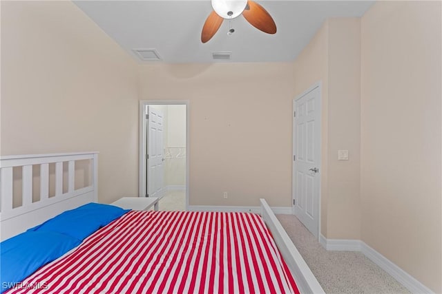 unfurnished bedroom featuring ceiling fan, a walk in closet, a closet, and light carpet