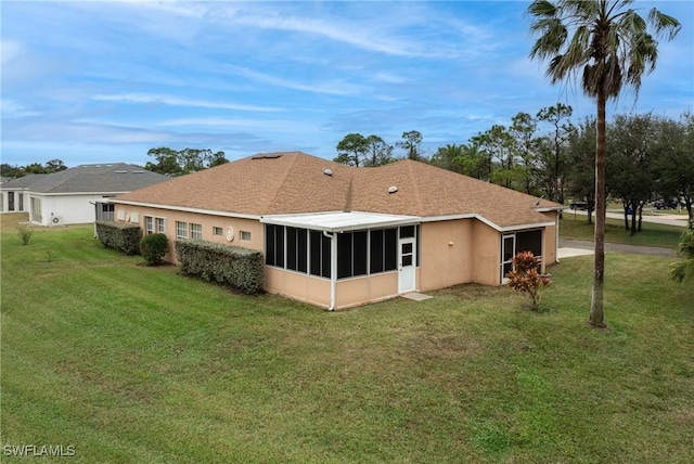 back of property featuring a sunroom and a yard