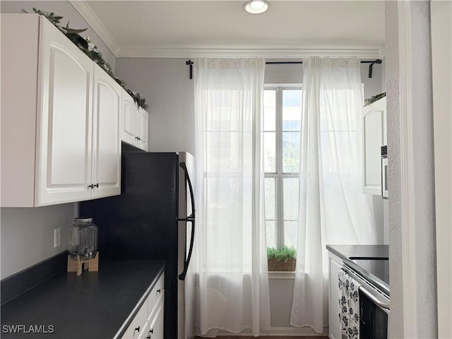 kitchen featuring crown molding, stainless steel range with electric stovetop, and white cabinets