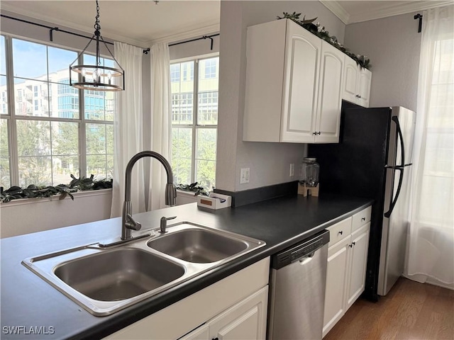 kitchen with sink, hanging light fixtures, stainless steel appliances, ornamental molding, and white cabinets