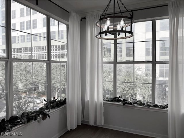 unfurnished dining area featuring a wealth of natural light, dark hardwood / wood-style flooring, and a notable chandelier