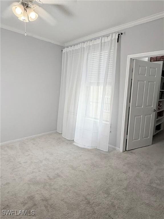 unfurnished bedroom featuring ornamental molding, carpet floors, and ceiling fan