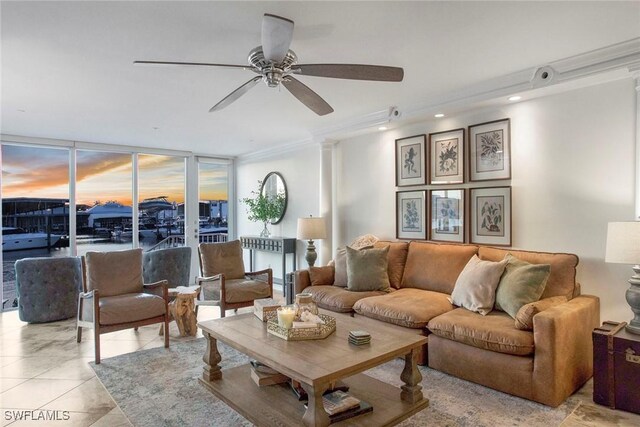 living room with floor to ceiling windows, ornate columns, crown molding, light tile patterned floors, and ceiling fan