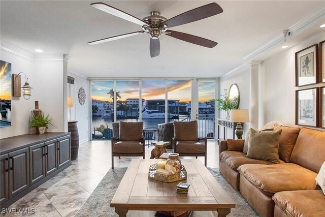 living room with ceiling fan, ornamental molding, floor to ceiling windows, and decorative columns