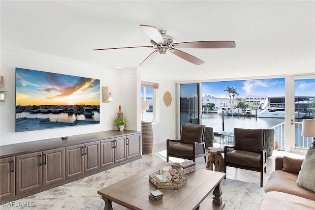 living room featuring ornamental molding, a water view, ceiling fan, and a wall of windows