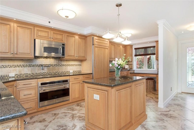 kitchen featuring a kitchen island, appliances with stainless steel finishes, pendant lighting, dark stone counters, and ornamental molding