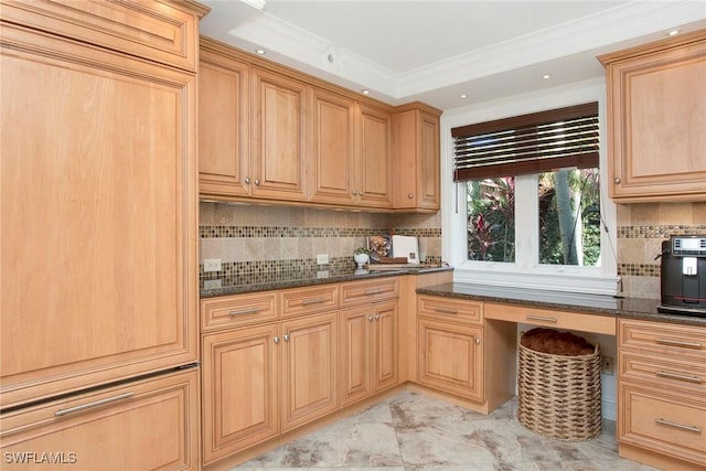 kitchen featuring crown molding, built in desk, decorative backsplash, and dark stone countertops