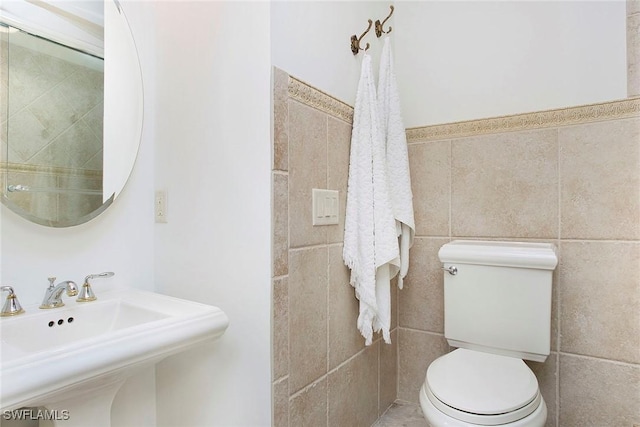 bathroom featuring tile walls, sink, and toilet