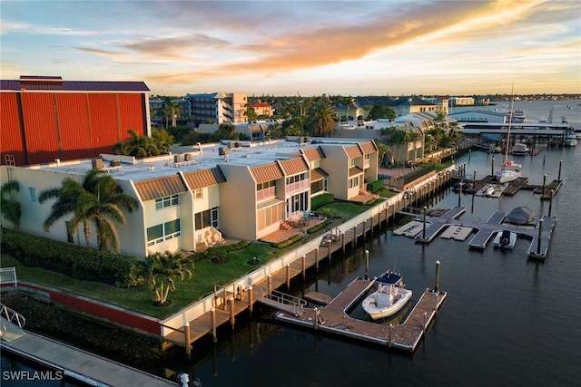 aerial view at dusk featuring a water view