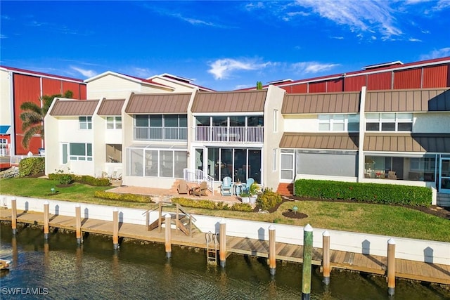 exterior space with a patio, a water view, and a yard