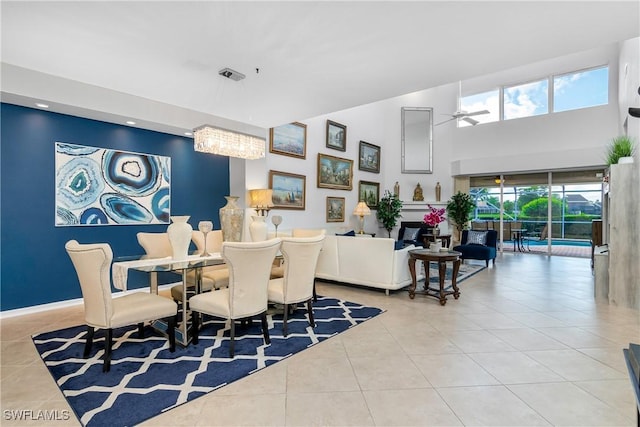 tiled dining room featuring ceiling fan with notable chandelier