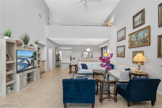 tiled living room featuring ceiling fan and a high ceiling