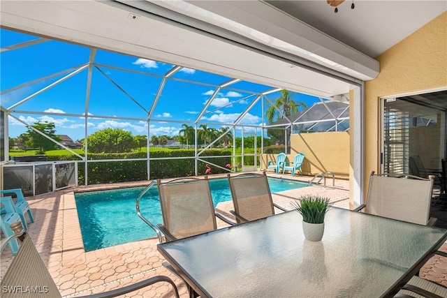 view of pool with a patio area and glass enclosure