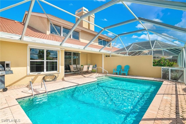 view of swimming pool with a lanai and a patio area