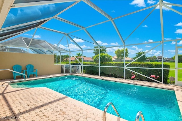 view of swimming pool featuring a patio area and glass enclosure