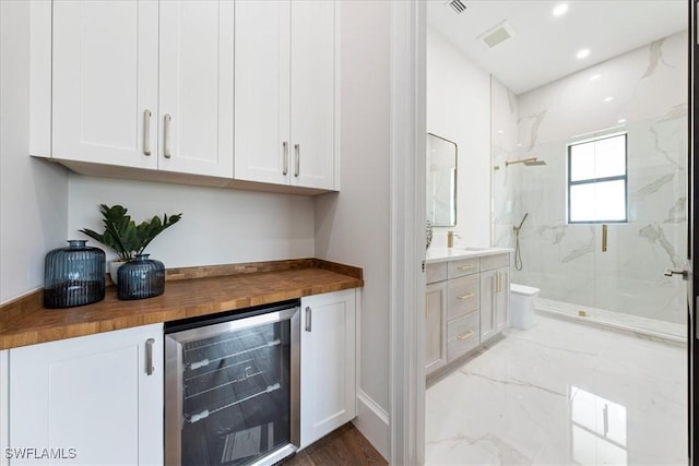 bar with white cabinets, butcher block counters, and wine cooler