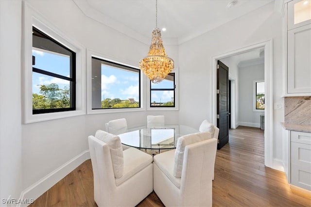 dining area featuring hardwood / wood-style floors, a chandelier, and ornamental molding