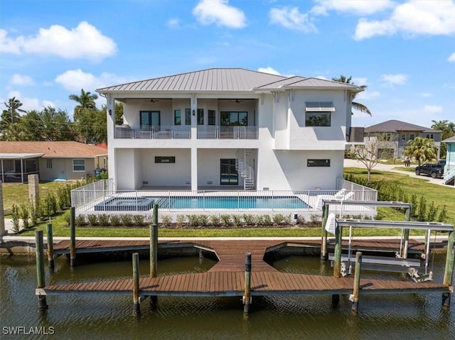 rear view of property featuring a balcony, a water view, and a patio