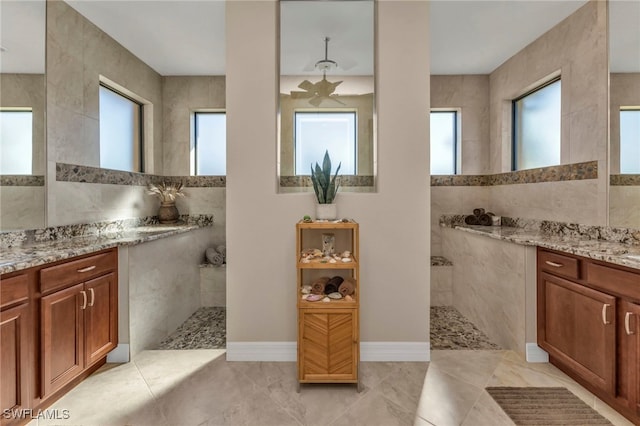 bathroom with plenty of natural light, tile walls, and vanity