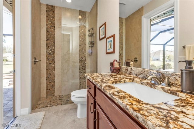 bathroom featuring tiled shower, toilet, and vanity