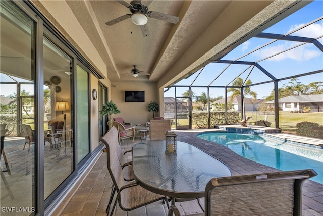 view of swimming pool with glass enclosure, a jacuzzi, ceiling fan, and a patio