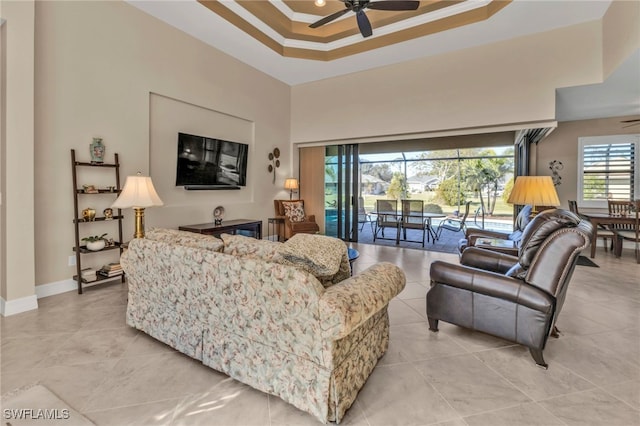 living room featuring crown molding, ceiling fan, and a raised ceiling