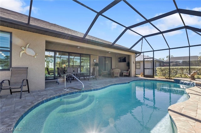 view of pool featuring a patio, glass enclosure, and pool water feature