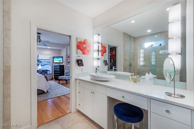 bathroom with tiled shower, tile patterned floors, and vanity