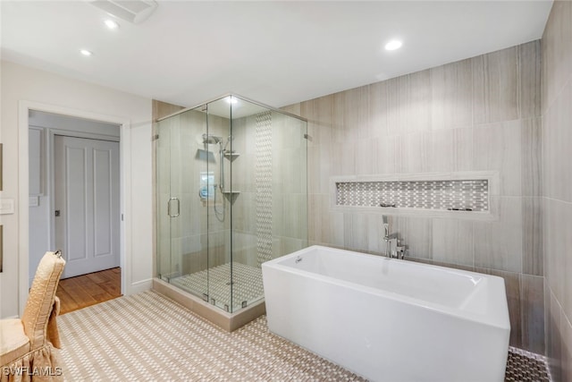 bathroom featuring wood-type flooring and shower with separate bathtub