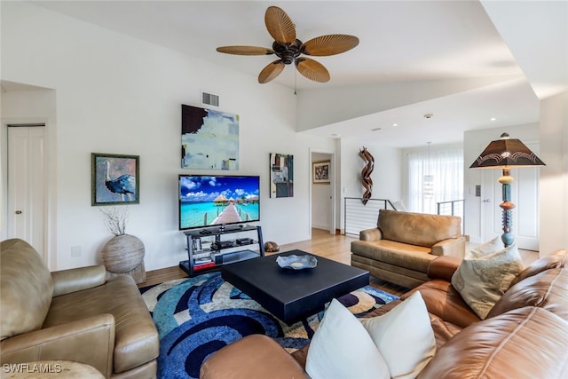 living room featuring light hardwood / wood-style floors, ceiling fan, and vaulted ceiling