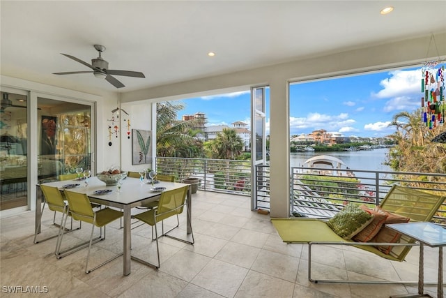 sunroom / solarium with a water view and ceiling fan