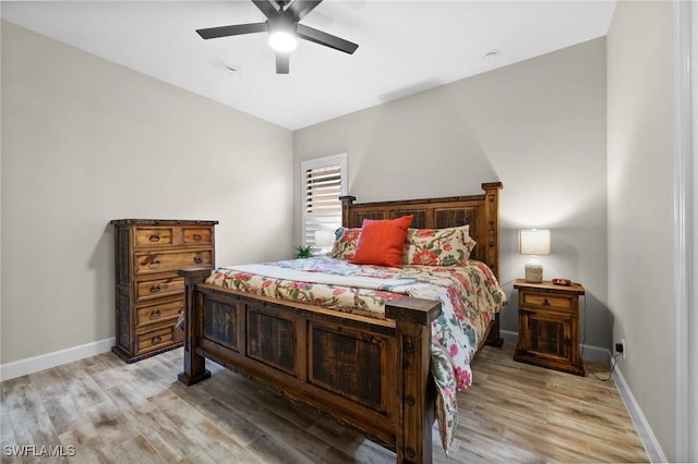 bedroom featuring baseboards, a ceiling fan, and light wood-style flooring