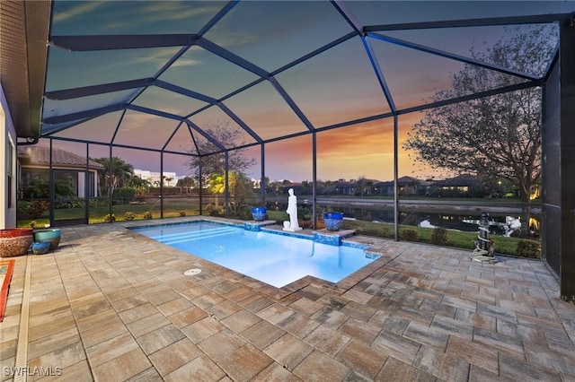 pool at dusk featuring a patio, a lanai, and an outdoor pool