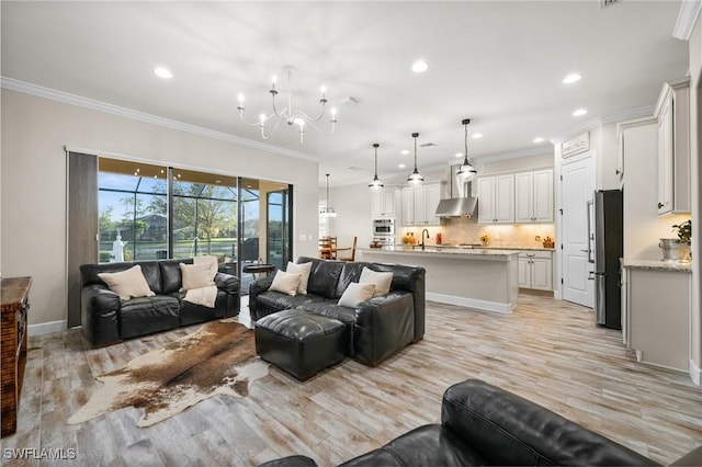 living area featuring recessed lighting, ornamental molding, light wood finished floors, and a chandelier