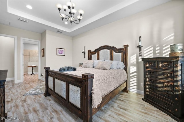 8750 Cavano St E, Naples, FL 34119 - bedroom featuring a chandelier, wood finished floors, a raised ceiling, and recessed lighting